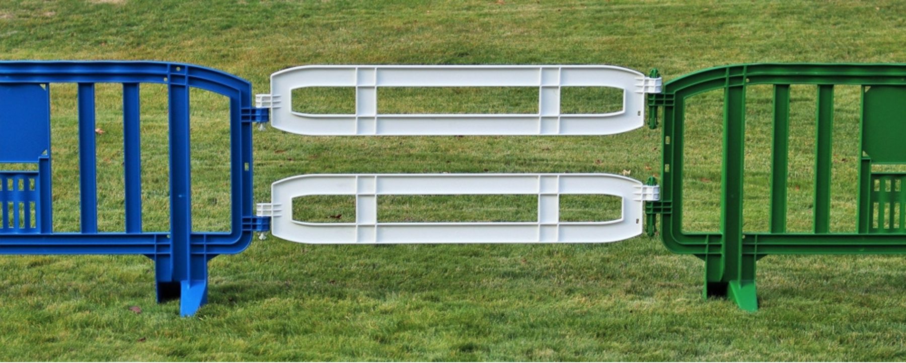 Two white Xtendit extension rails connecting blue and green FP-39 plastic barricades