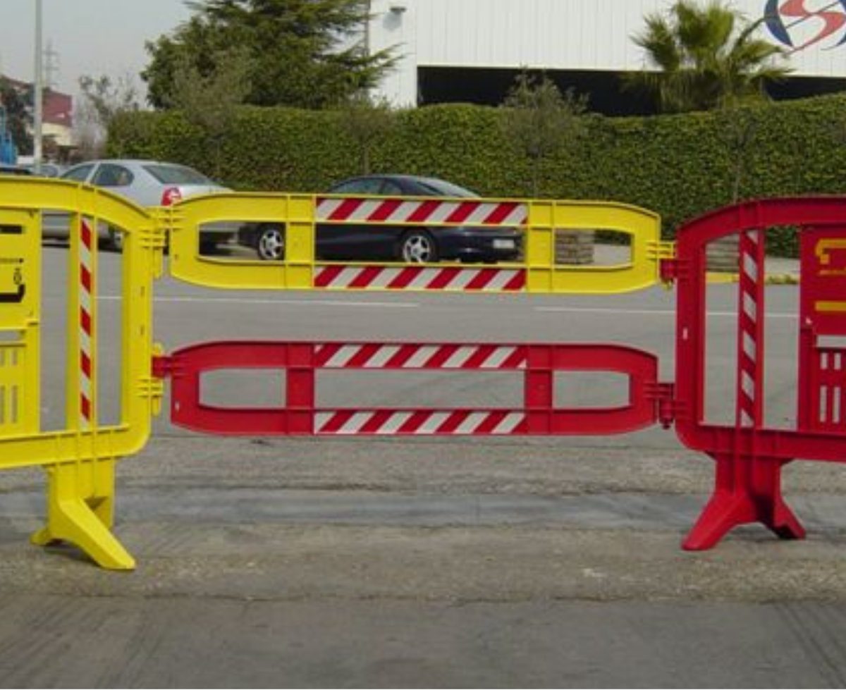 Yellow and red Xtendit extension rails forming a gate between plastic barricades